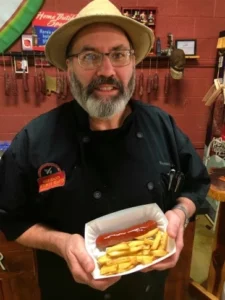 Mike Sloan holding currywurst with fries