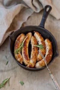 5 bratwursts in a frying pan