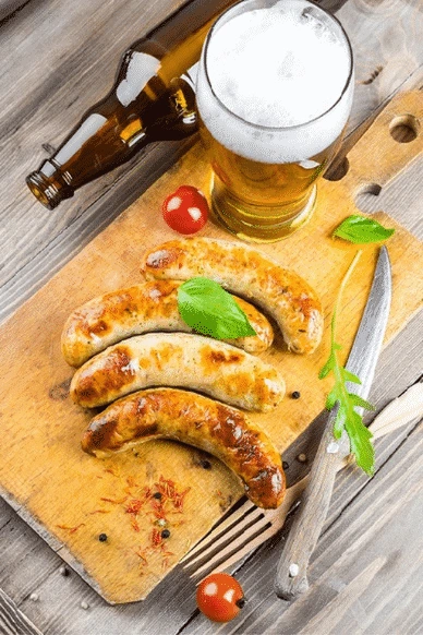 Bratwursts on a cutting board and a mug of beer