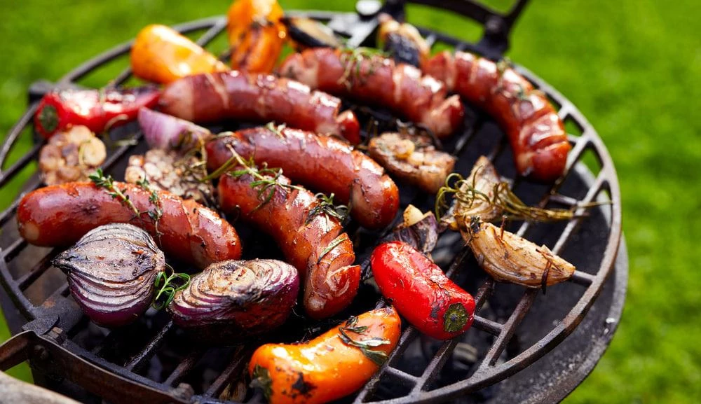 Bratwursts with vegetables on the grill